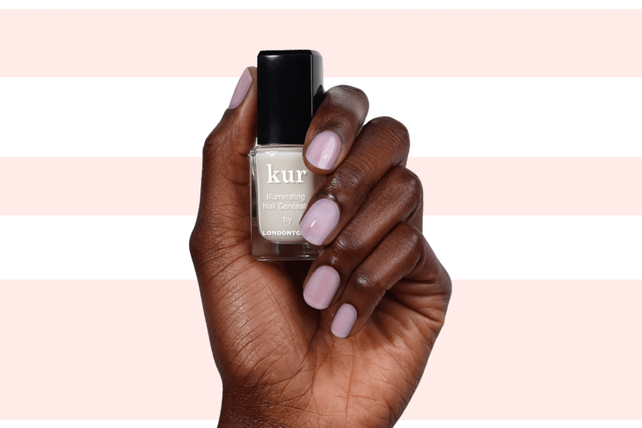 hand with polished nails holding a bottle of nail concealer